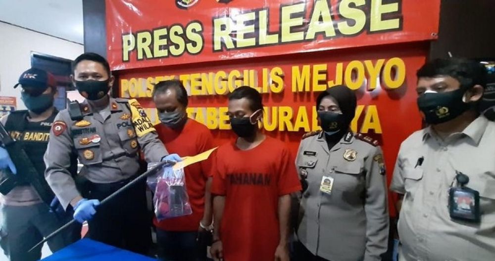 Kedua tersangka pembobolan beserta barang bukti linggis yang digunakan untuk membobol ditunjukkan dalam rilis kasus di Mapolsek Tenggilis Mejoyo. 