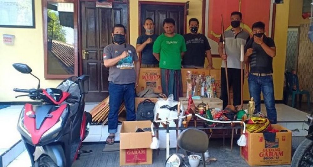 Dukun gadungan di Malang beserta sejumlah barang bukti yang digunakan untuk menipu korbannya diamankan petugas. 