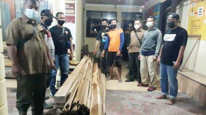 Petugas menunjukkan kayu jati yang dicuri. 