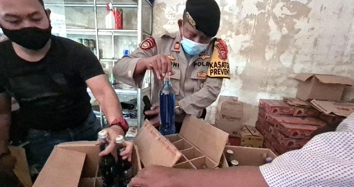 Polisi mengamankan ratusan dus miras dan isinya saat menggerebek rumah mewah di Sukabumi. 
