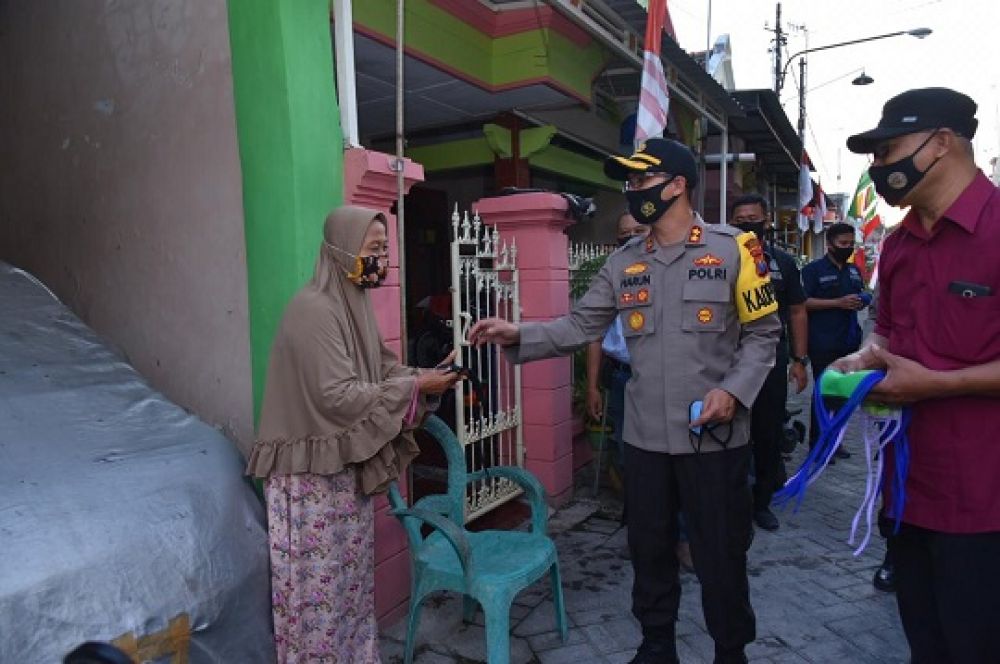 Kapolres Lamongan AKBP Harun saat membagikan masker ke warga Lamongan dengan mendatangi rumah warga. SP/MUHAJIRIN KASRUN