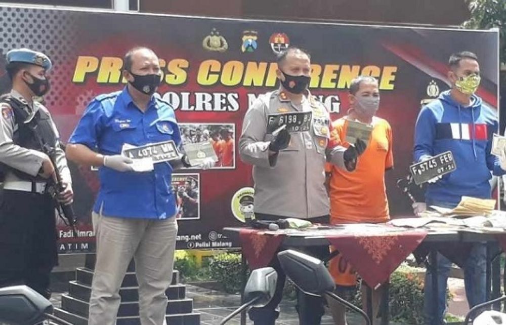 Kapolres Malang, AKBP Hendri Umar menunjukkan plat nomor motor gedrikan yang disita sebagai barang bukti dalam kasus ini. 
