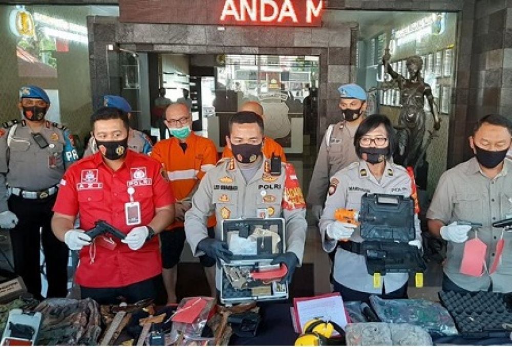 Polisi menunjukkan barang bukti senjata api illegal milik tersangka saat rilis kasus. 