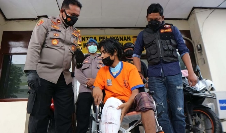 Tersangka Andrew Setiawan duduk di korsi roda setelah dilumpuhkan polisi. SP/Mahbub Fikri