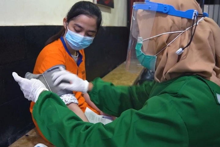 Seorang tahanan wanita Polres Gresik saat divaksin petugas kesehatan. SP