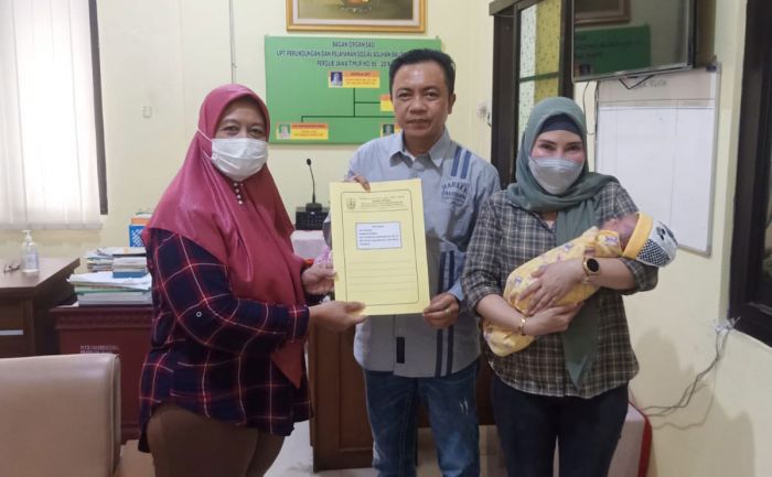 Wabup Blitar Rahmat Santoso menunjukkan dokumen adopsi anak didampingi sang istri (menggendong bayi).