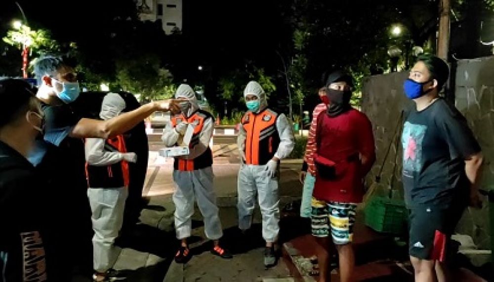 Petugas dari Satres Narkoba Polrestabes Surabaya menegur para pemuda yang kedapatan masih nongkrong meski telah melewati jam malam yakni pukul 24.00 WIB. SP/Jemmy