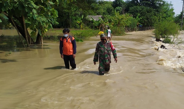 Petugas BPBD dan TNI sedang melintas di salah satu jalan desa yang tergenang banjir meluapnya Kali Lamong. SP/ BPBD Gresik