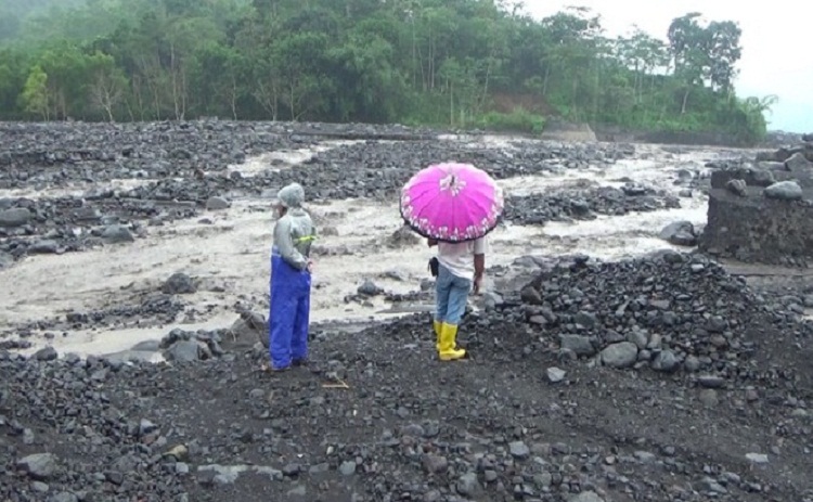 Petugas saat memeriksa aliran sungai yang dilintasi banjir lahar hujan Semeru. SP/ BPBD Sidoarjo