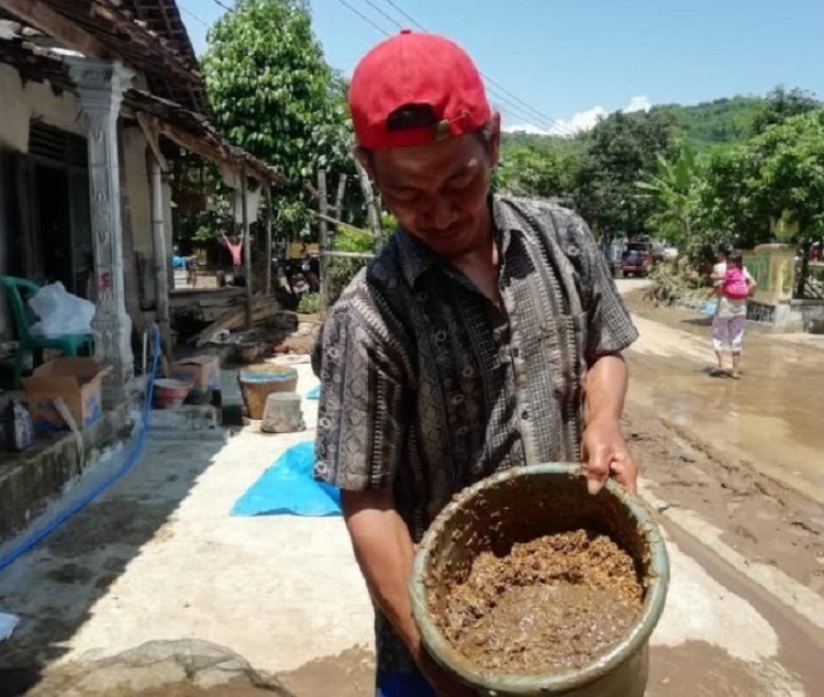 Warga Desa Banjarpanjang saat memisahkan gabah dengan lumpur akibat banjir. SP/ BPBD Magetan