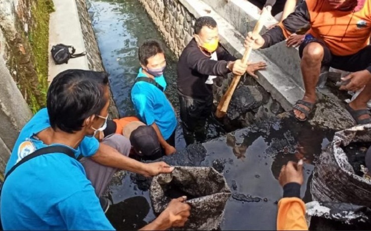 Bupati Sugiri Sancoko membersihkan sampah di aliran air jalan Subokastowo. SP/ PNG