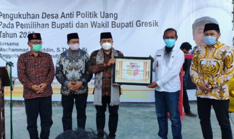 Anggota Bawaslu RI Muchammad Afifuddin menyerahkan sertifikat pengukuhan kepada Kades Sekapuk Abdul Halim. SP/M. AIDID