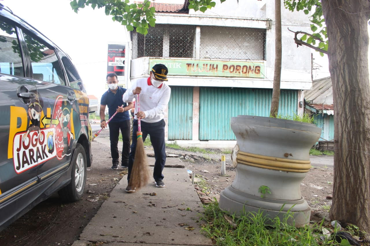 Pj. Bupati Sidoarjo sedang menyapu halaman jaga kebersihan taman. SP/ Sugeng Purnomo