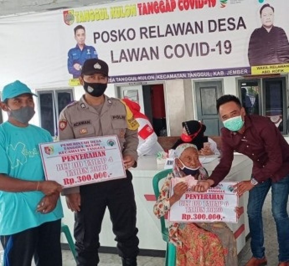 Kades Arifin saat menyerahkan BLT DD kepada salah satu warga dengan didampingi perangkat dan tiga pilar Desa Tanggul Kulon. SP/ JT