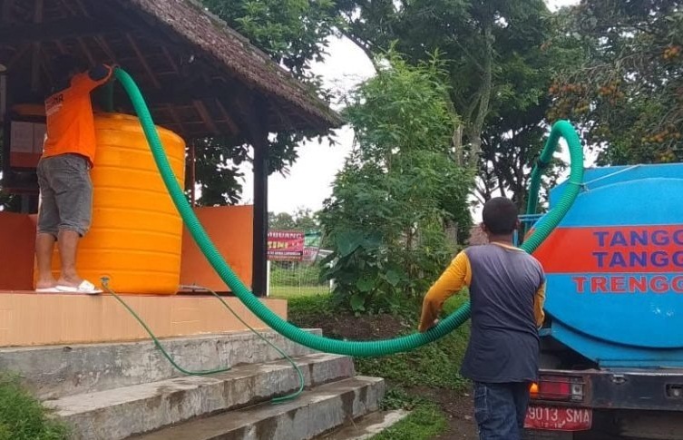 Petugas saat melakukan dropping air bersih bagi warga yang terdampal. SP/ BJ