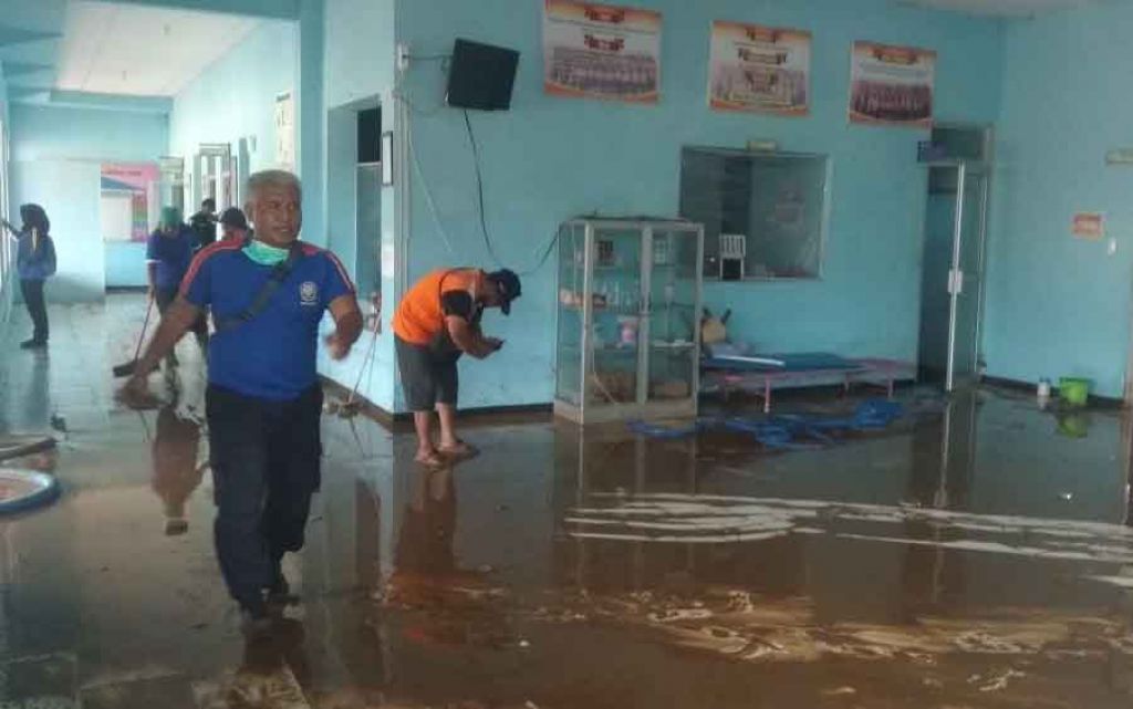 Petugas yang membersihkan Puskesmas Kebonagung yang terendam banjir. SP/ JN