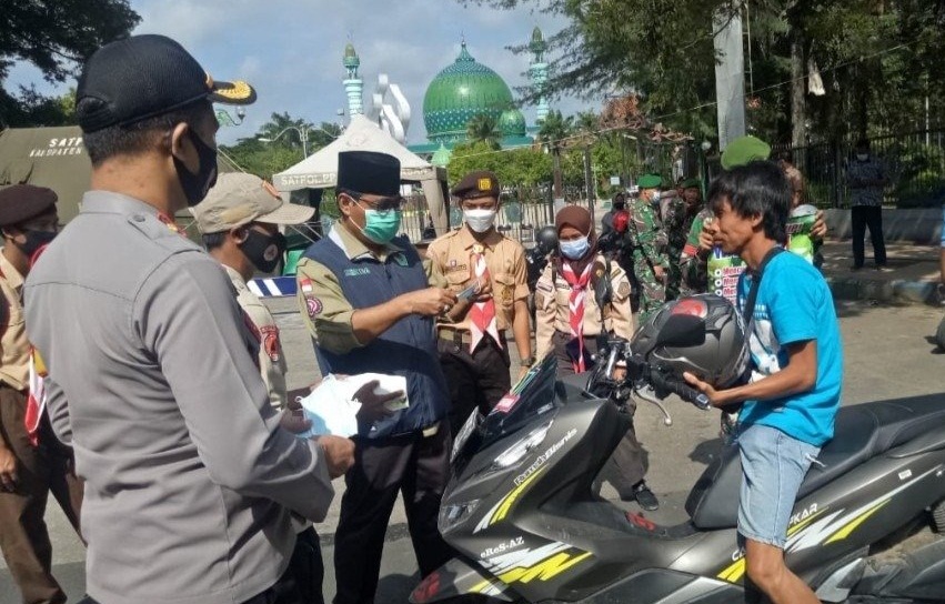 Sekda Pamekasan, Ir Totok Hartono (tengah) membagikan masker kepada pengguna. SP/ BJ