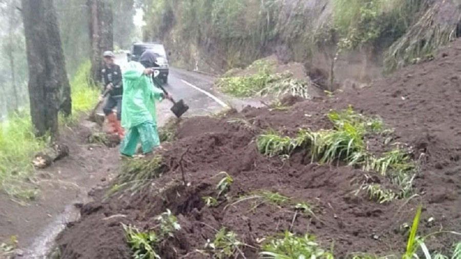 Petugas sedang membersihkan sisa tanah akibat longsor di Tosari. SP/ DECOM