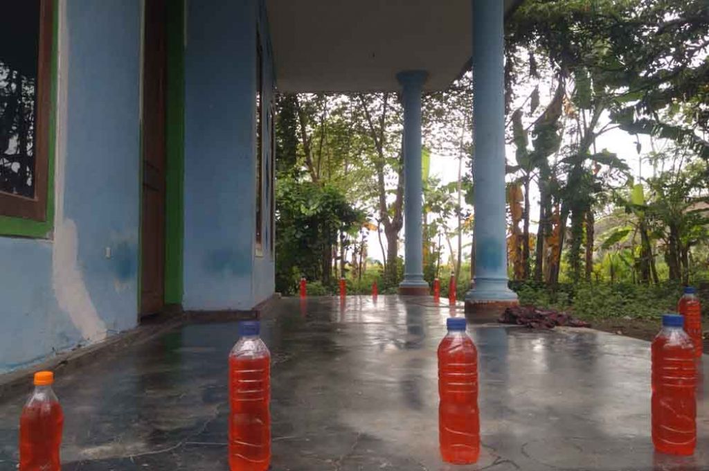 Sejumlah botol yang berisi cairan merah berada di teras rumah warga. SP/ JN