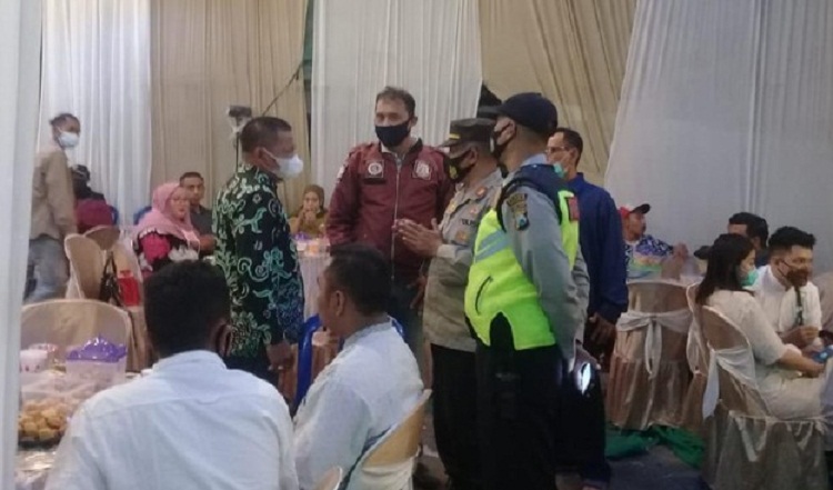 Petugas memberikan pengertian kepada pemilik hajatan sebelum menghentikannya. SP/ DECOM