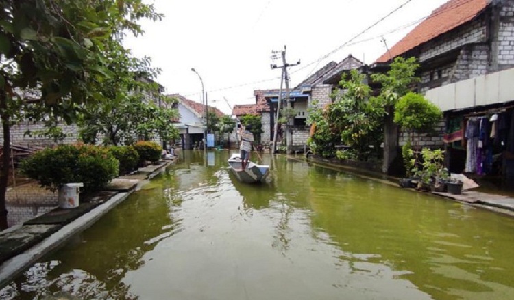 Warga yang menaiki Perahu di atas banjir di Lamongan. SP/ DECOM