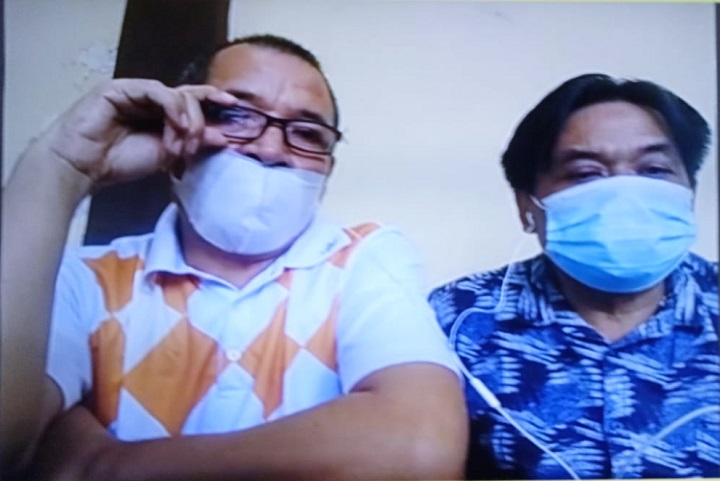 Terdakwa Made (kiri) dan Wayan saat mendengarkan majelis hakim membacakan amar putusan dalam sidang di ruang Candra PN Surabaya, secara online, Kamis (02/09/2021). SP/Budi Mulyono