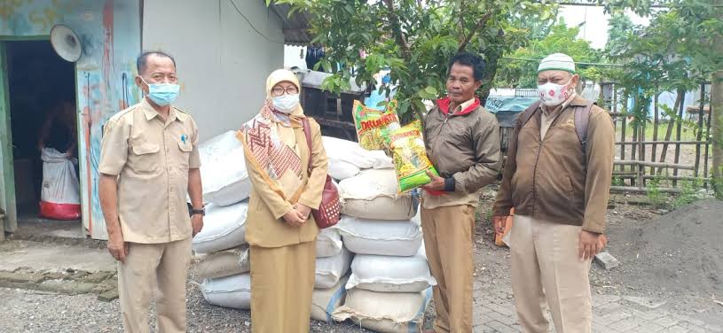 Petugas dari Dispertan &  Ketahanan Pangan menyalurkan pupuk bersubsidi di lapangan kepada petani.
