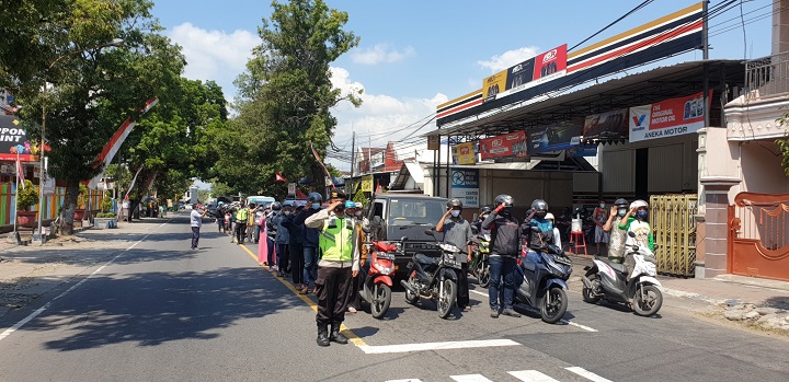Suasana penghormatan detik detik Proklamasi dengan iringan Lagu Kebangsaan di perempatan Jalan Raya. SP/Hadi Lestariono
