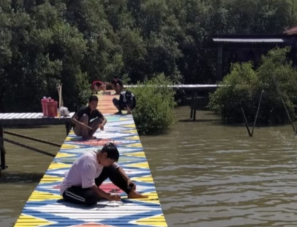 Tampak para pemuda sedang melakukan pengecatan geladak Pantai Karangkering, Gresik. SP/ KJ