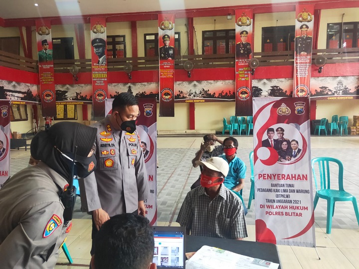 Kapolres Blitar AKBP Adhitya Panji Anom  saat berbincang dengan salah satu warga penerima BTP KLW. SP/Hadi Lestariono