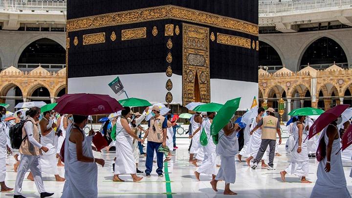 Sejumlah umat muslim menggunakan payung saat melakukan tawaf dengan menerapkan social distancing saat melaksanakan ibadah haji di tengah pandemi Covid-19. SP/Saudi Ministry of Media via REUTERS