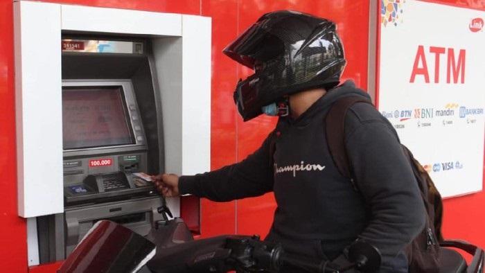 Salah satu pengendara sedang mengakses di ATM bersama yang dikelola ATM Link, di Jakarta, Minggu (23/5/2021). SP/Himbara