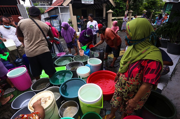 Warga mengantre untuk mendapatkan air bersih dari tangki air PDAM Surya Sembada, di kawasan Nginden Jangkungan Surabaya, Jawa Timur, Senin (25/1/2021). SP/Julian