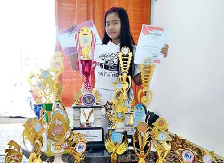 Avriel Berliana Syafaatu Zamanie menunjukkan koleksi puluhan piala yang telah dia dapatkan. SP/ TLG