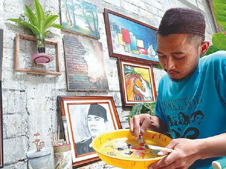 Bahak saat sedang melukis salah satu karya pesanannya. SP/ BLT
