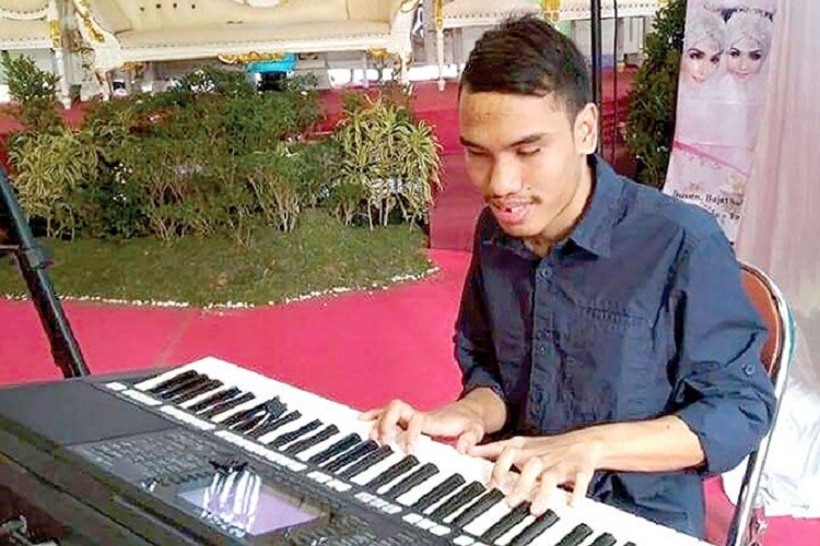 Fajar Calvino Samsu Dhuha, seorang pemuda tunanetra yang sedang memainkan keyboard. SP/ TLG
