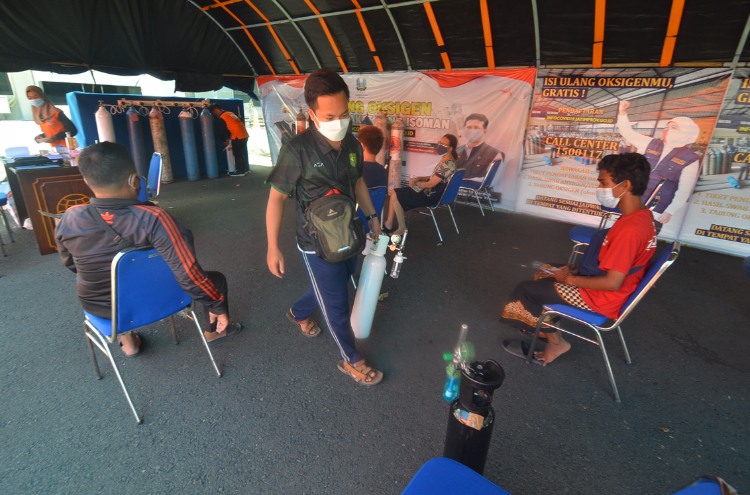 Warga mengantri sesusai melakukan pengisian oksigen di halaman kantor Dishub Jatim, Surabaya, Senin (19/7/2021). Sp/Arlana