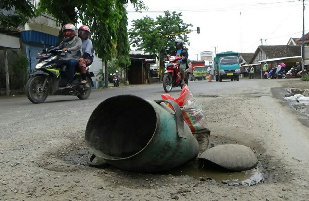 Ilustrasi. Berbahaya, salah satu titik jalan deandles (jalan nasional) yang rusak, diberi tanda dengan bekas bak sampah oleh warga Betoyo Manyar Gresik.SP/BG