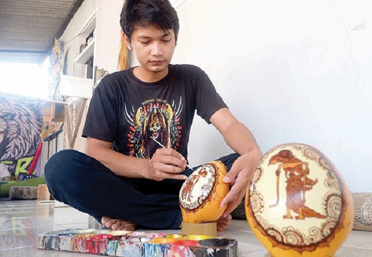 Danang Prasetyo Laksono melukis kelapa gading. SP/ TLG