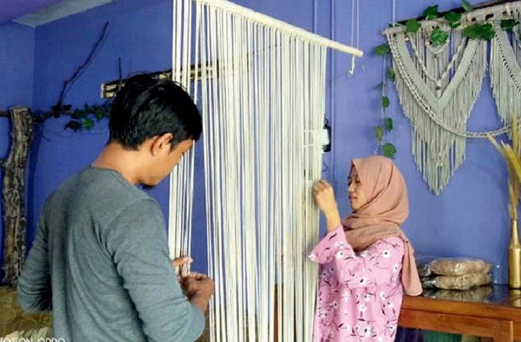 Desy Eki Hariani Putri sedang sibuk membuat kerajinan macrame. SP/ TLG