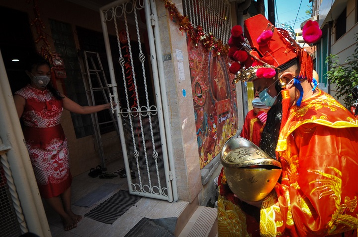 Seorang pria berkostum Dewa Rejeki berkeliling di perkampungan pecinan kawasan Kampung Cina, Kapasan Dalam, Surabaya, Jawa Timur, Jumat (12/2/2021). SP/Julian