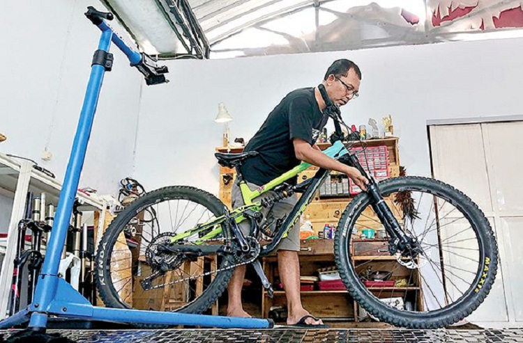 Dhiyan mengatur suspensi sepeda downhill. SP/ BLT