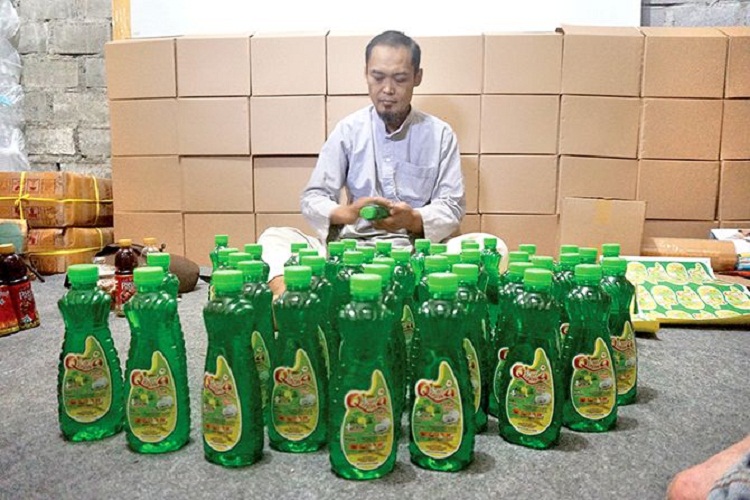 Edi Cahyono saat mengemasi produk sabun cuci miliknya. SP/ SBY
