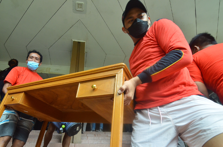 Petugas mengangkut barang-barang milik hotel Singgasana saat eksekusi lahan di Hotel Singgasana, Surabaya, Senin (17/1/2022). Sp/Arlana