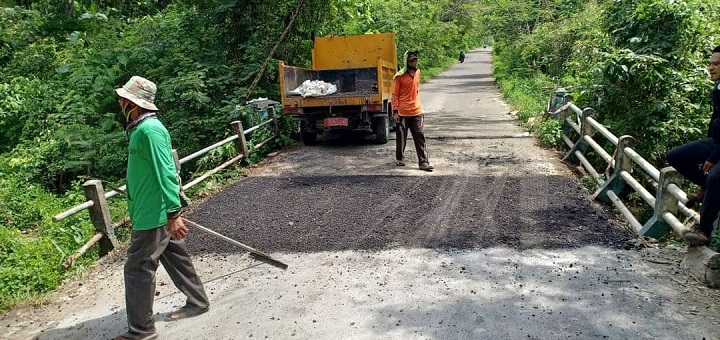 Pekerja saat memperbaiki jembatan yang ambles, bahkan bagian atas jembatan langsung diaspal. SP/MUHAJIRIN KASRUN