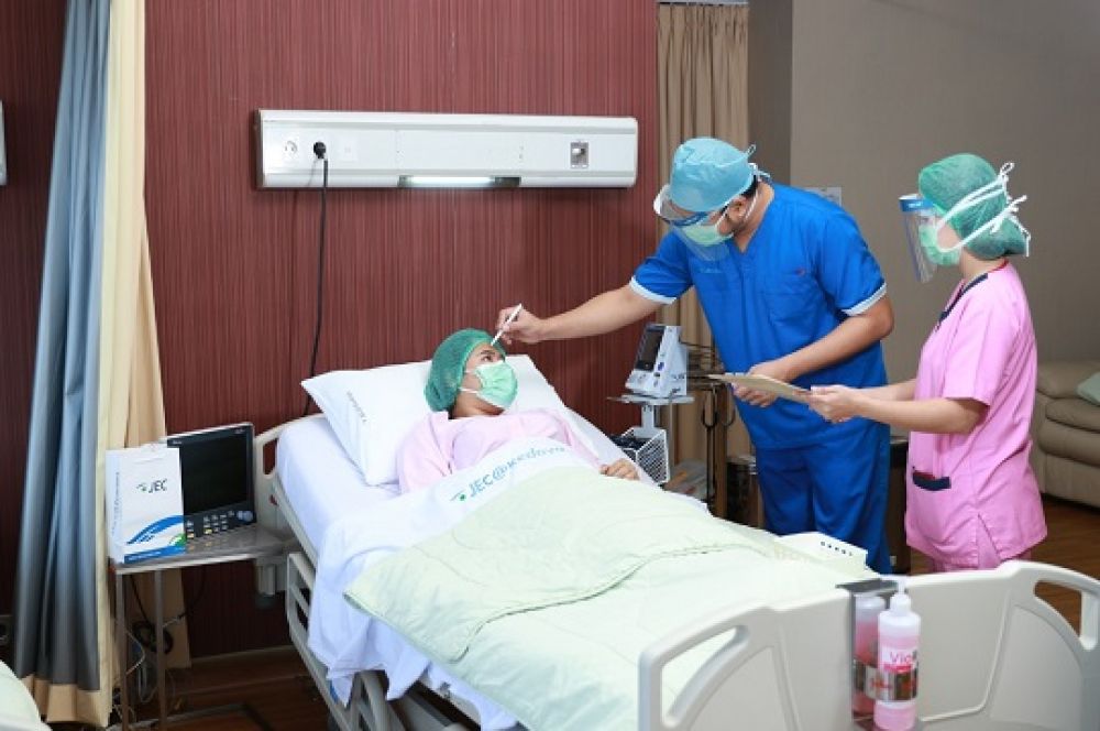 Staf medis melakukan pemeriksaan terhadap salah satu pasien.