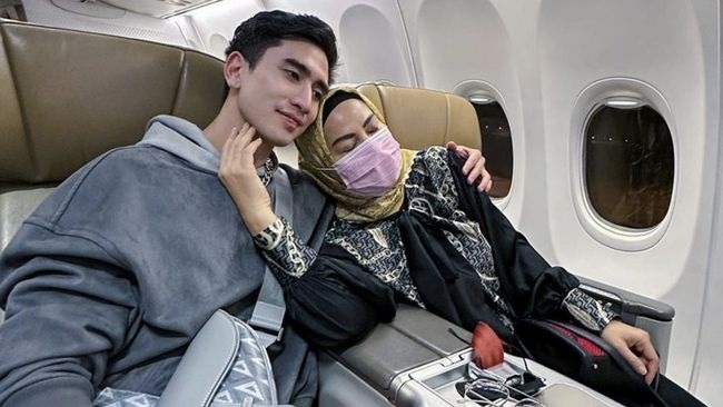 Venna Melinda, dikawal anak pertamanya, Verrel Bramasta di dalam pesawat, setelah dirinya hadir dalam pemeriksaan di Polda Jatim. Verrel terus selalu mengawal ibunya itu.