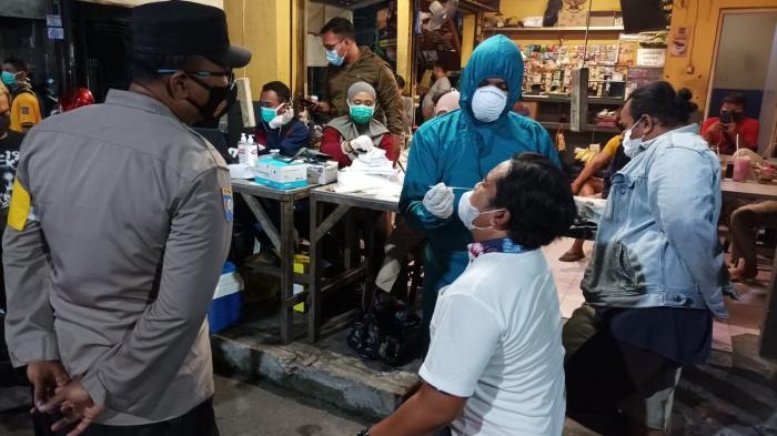 Omicron mengganas, Pemkot Surabaya Sebar Swab Hunter di pusat keramaian, salah satunya di Warkop di wilayah Ngagel, kemarin. Mereka yang terjaring razia langsung di-swab. SP/Amin