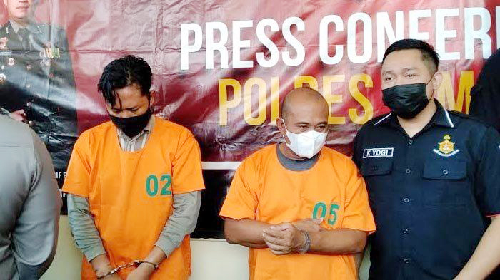Fitroni Ramadhani dan Ahmad Riyadi, dua tersangka penipuan dan penggelapan terhadap Kades, dibekuk di halaman Polsek Wuluhan, Rabu (26/5/2021). SP/dik/kontributor jember