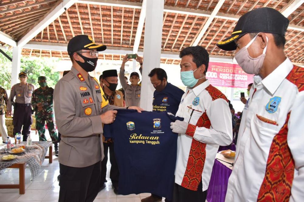 Kapolres Lamongan AKBP Harun membagikan kaos kepada masyarakat.

FOTO:SP/MUHAJIRIN KASRUN